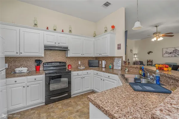 a kitchen with a sink dishwasher and white cabinets
