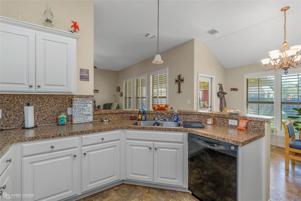 7193 Laurel Ridge Drive Greenwood, LA 71033 - Photo 28 of 40 Kitchen with white cabinetry, dishwasher, a peninsula, suspended lighting, and lofted ceiling