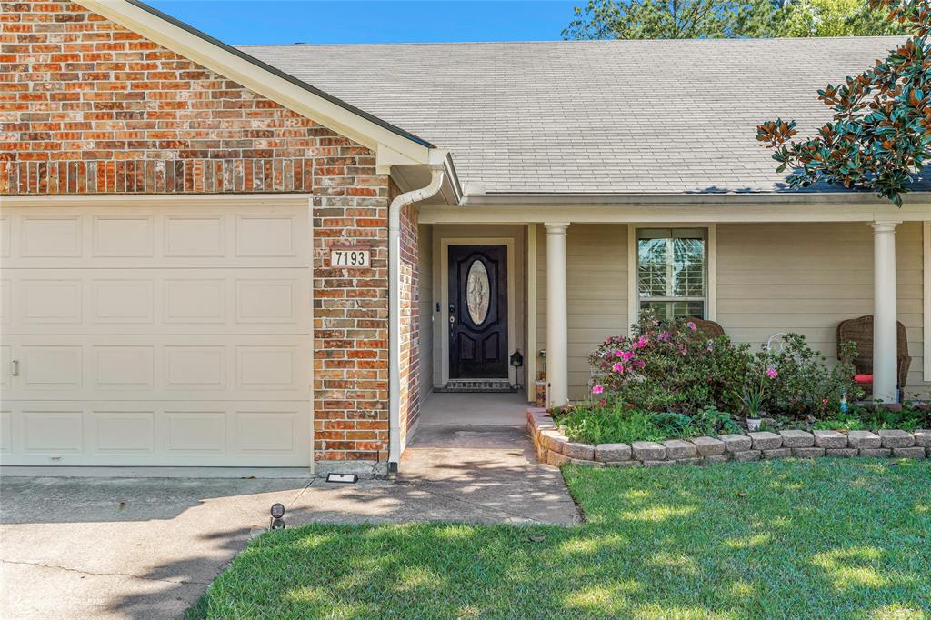 7193 Laurel Ridge Drive Greenwood, LA 71033 - Photo 3 of 40 Doorway to property featuring an attached garage, a shingled roof, brick siding, a lawn, and concrete driveway