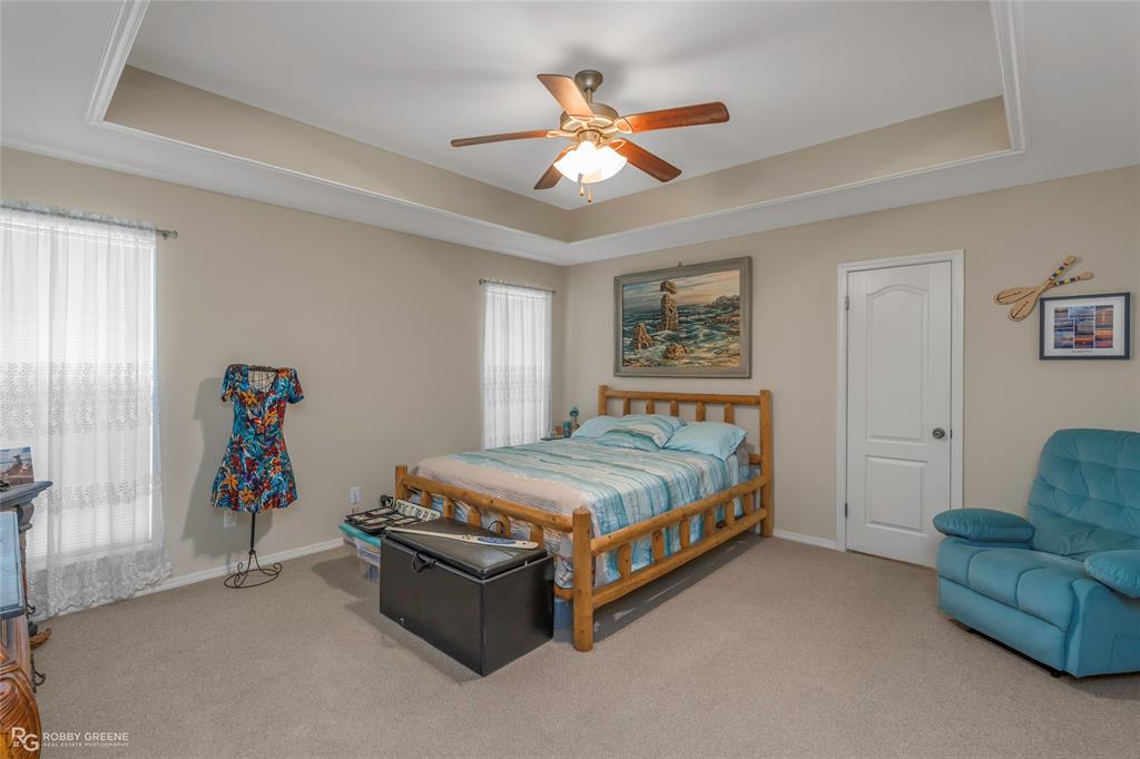 7193 Laurel Ridge Drive Greenwood, LA 71033 - Photo 36 of 40 Bedroom with a tray ceiling, light carpet, and a ceiling fan
