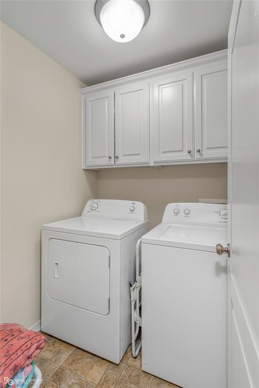 7193 Laurel Ridge Drive Greenwood, LA 71033 - Photo 40 of 40 Laundry area with cabinet space, washer and clothes dryer, and stone finish floors