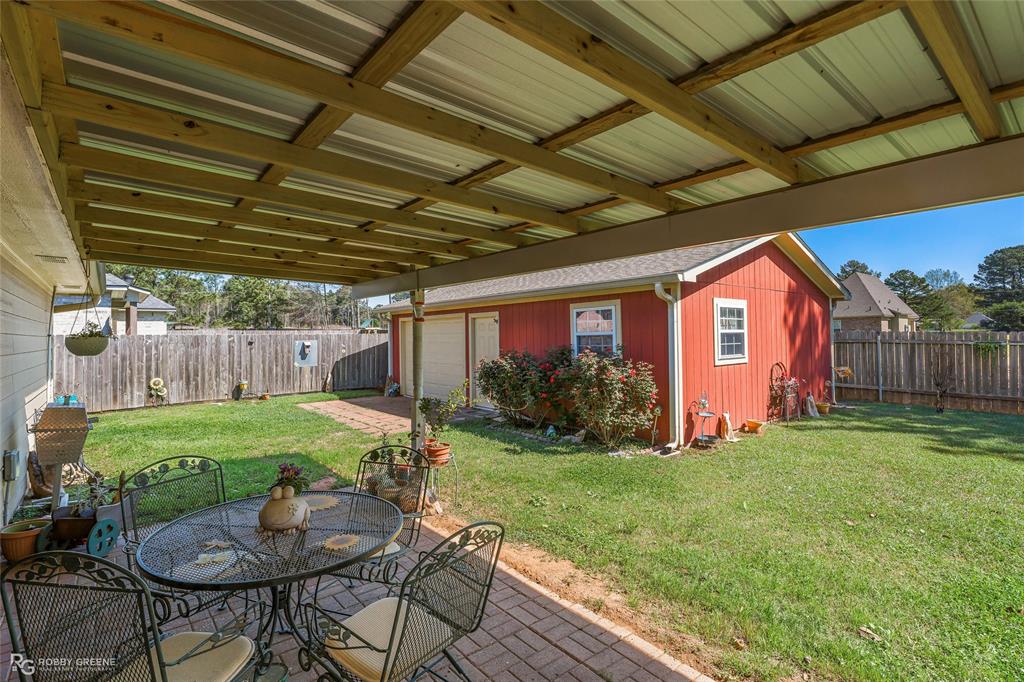 7193 Laurel Ridge Drive Greenwood, LA 71033 - Photo 6 of 40 Fenced backyard with a patio area, an outbuilding, and outdoor dining space