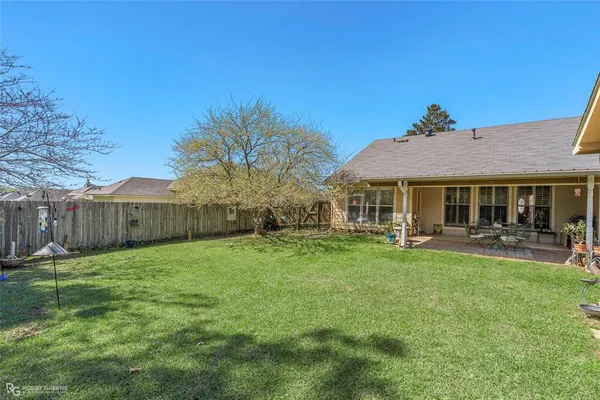 a backyard of a house with table and chairs