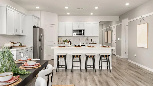 a kitchen with stainless steel appliances granite countertop a sink stove and refrigerator