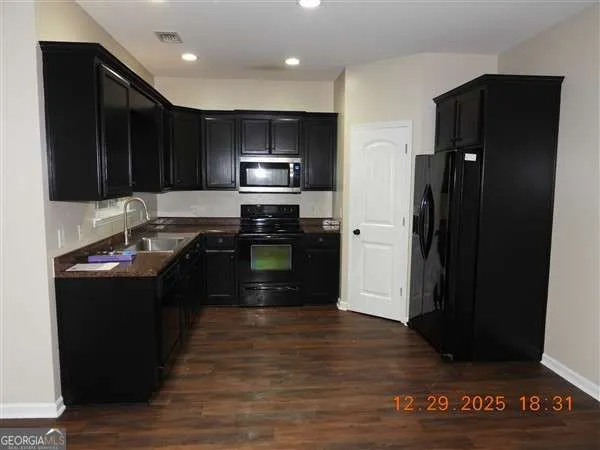 a kitchen with a refrigerator and a stove