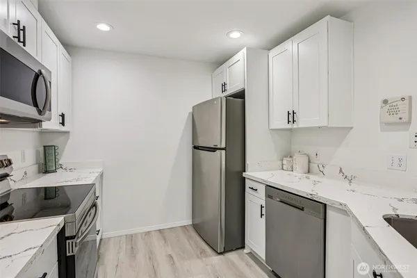 a kitchen with stainless steel appliances a refrigerator sink and microwave
