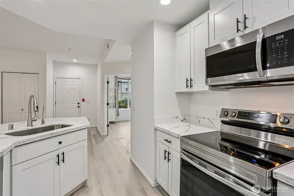 a kitchen with stainless steel appliances a stove microwave and cabinets