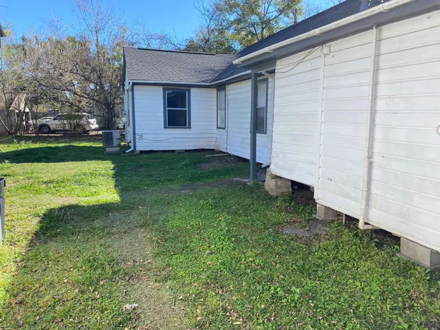 a view of backyard with potted plants and large tree