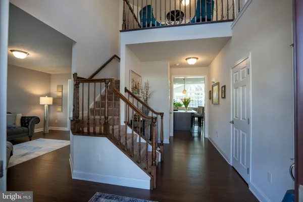 a view of a hallway with wooden floor stairs