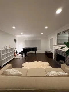 a living room with furniture a fireplace and kitchen view