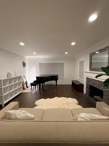 a living room with furniture a fireplace and kitchen view