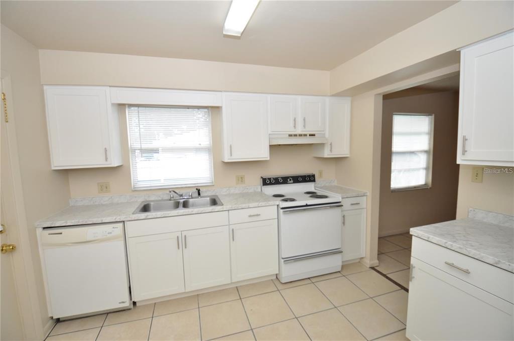 1434 East Fern Road, Unit 1434 Lakeland, FL 33801 - Photo 6 of 13 a kitchen with white cabinets appliances and a window