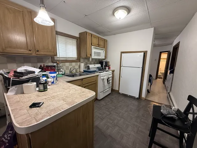 a kitchen with a sink a stove and chairs