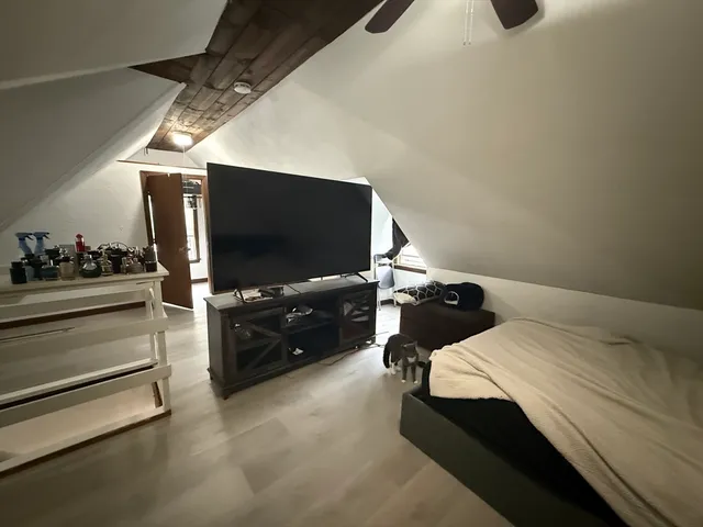 a bedroom with a bed and flat screen tv