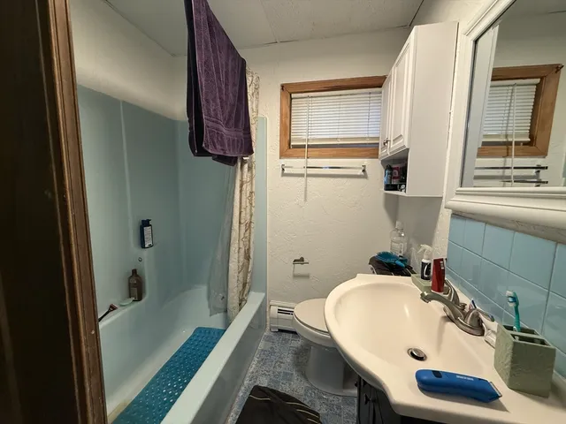 a bathroom with a sink and mirror with bathtub