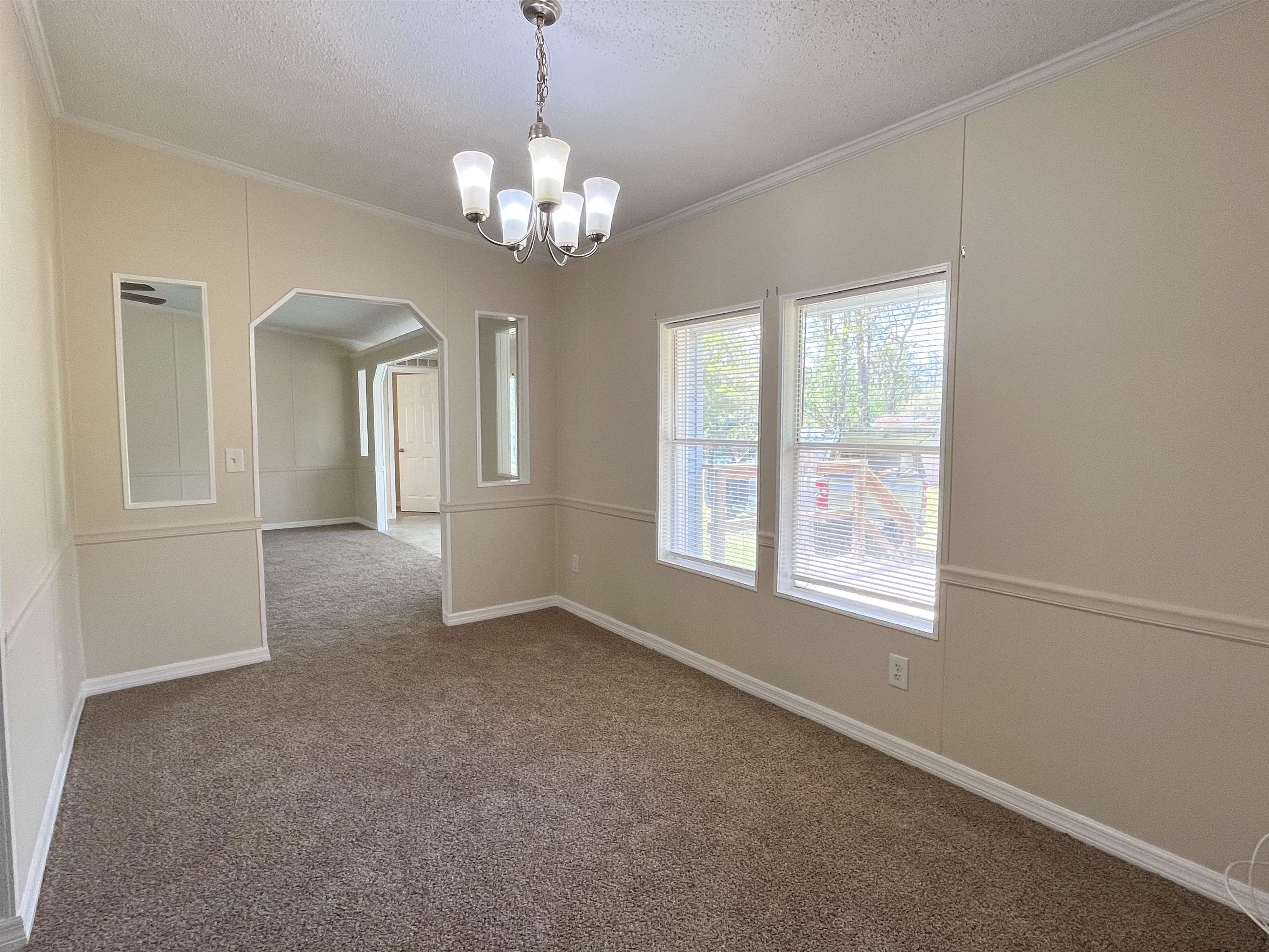 1340 Thompson Bailey Road St. Augustine, FL 32084 - Photo 11 of 21 an empty room with chandelier and windows