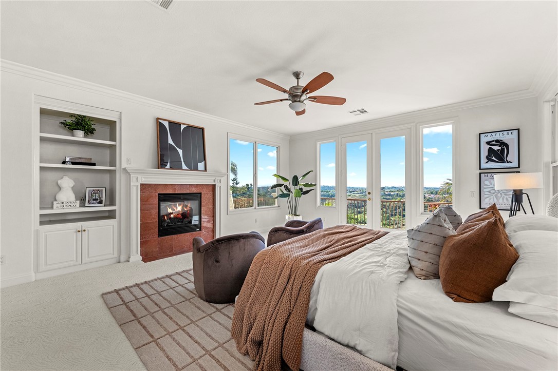 5464 Shannon Ridge Lane San Diego, CA 92130 - Photo 27 of 44 a bedroom with a large bed and a fireplace