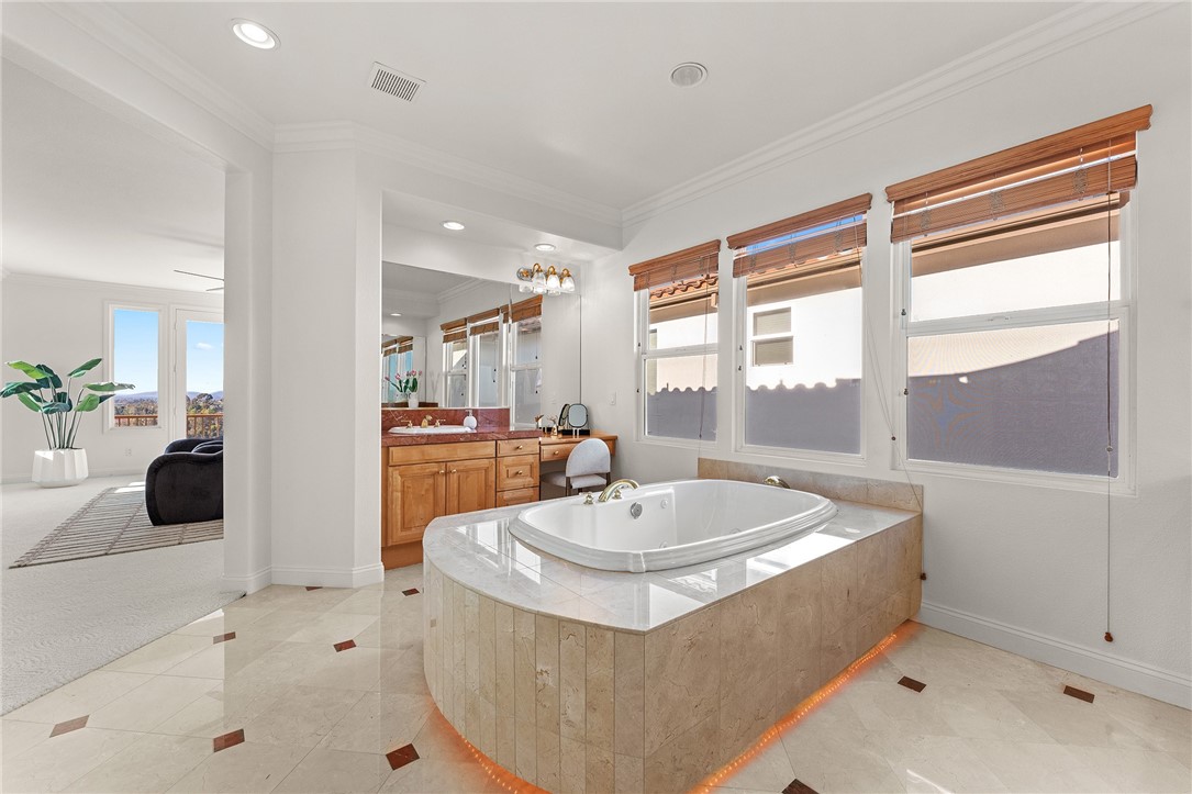 5464 Shannon Ridge Lane San Diego, CA 92130 - Photo 30 of 44 a bathroom with a tub a sink a mirror and a shower