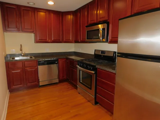 a kitchen with stainless steel appliances granite countertop a stove a sink dishwasher and a microwave oven on the blue kitchen countertops