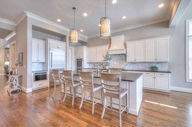 a view of an empty room with a window and a kitchen