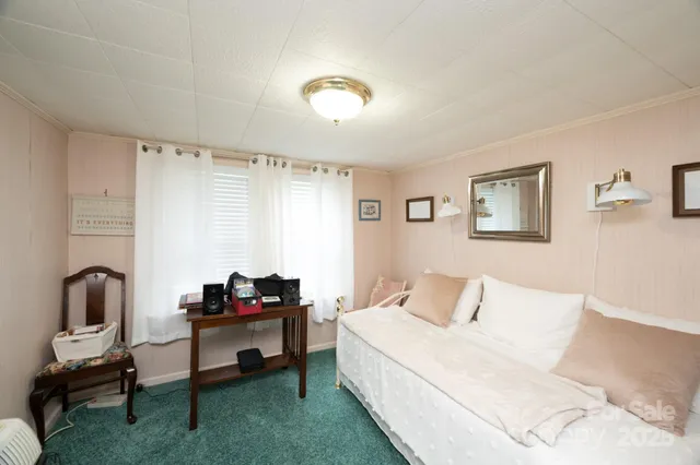 a bed sitting in a bedroom next to a window