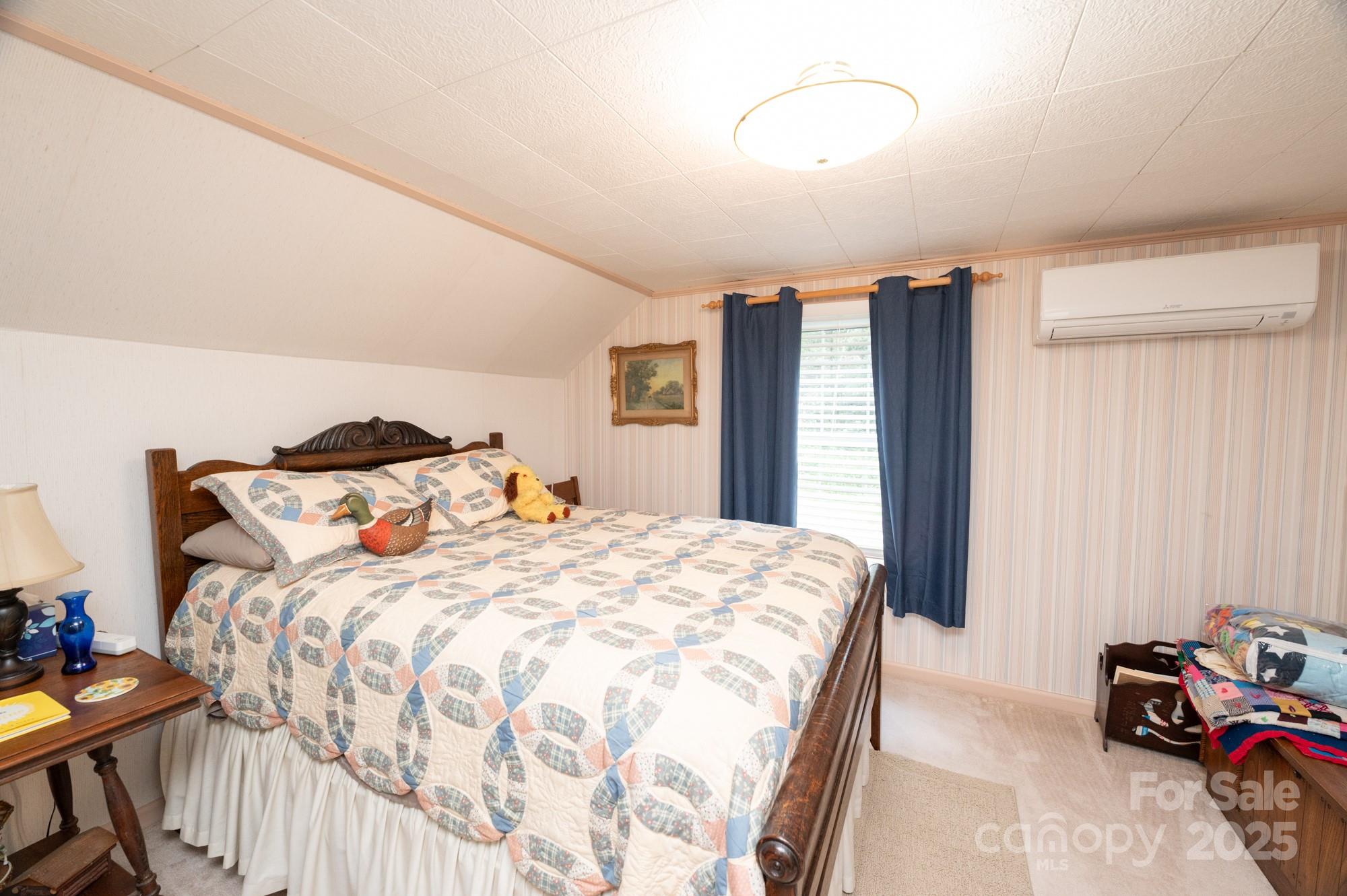 230 West Cove Lane Boone, NC 28607 - Photo 19 of 46 a bedroom with a bed and a chandelier