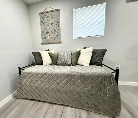 a bedroom with a bed and painting on the wall