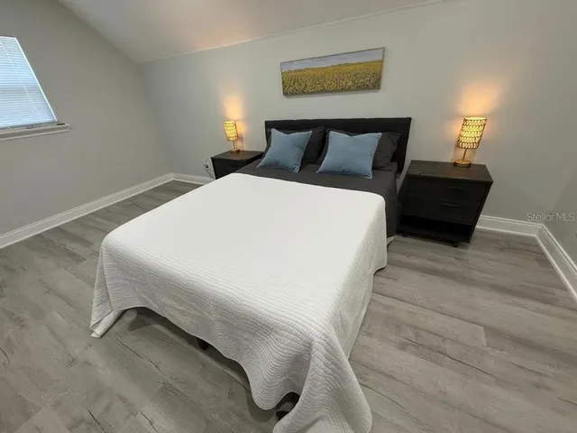 a spacious bedroom with a bed and a flat screen tv