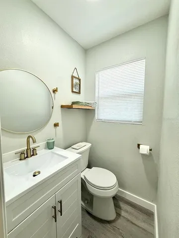 a bathroom with a toilet sink vanity and mirror