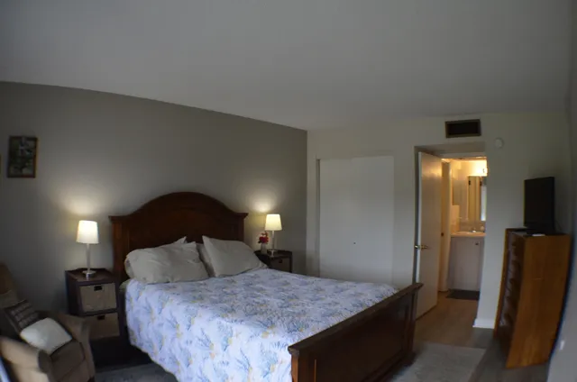 a bedroom with a bed and a mirror on dresser