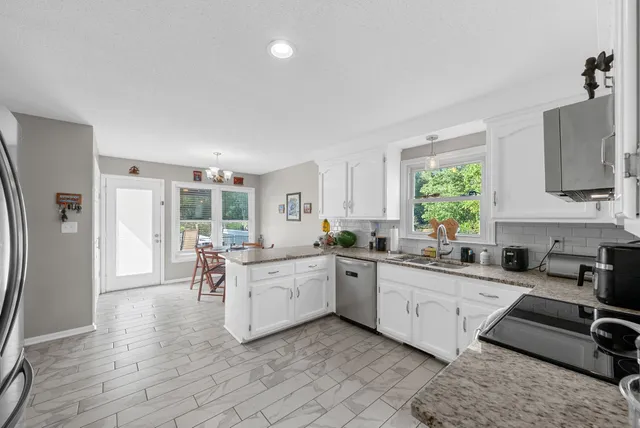 a kitchen with stainless steel appliances granite countertop a stove a sink and a granite counter tops