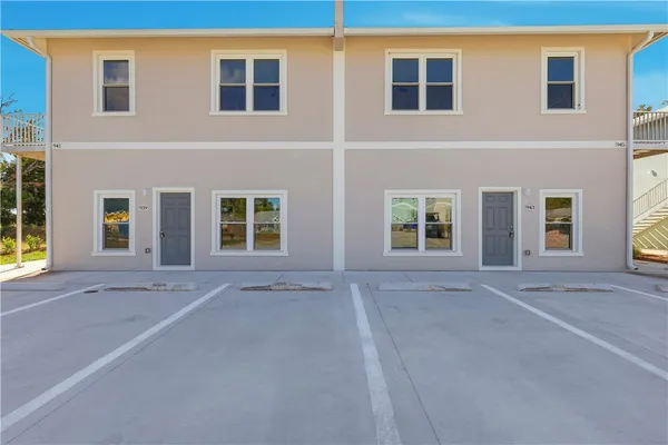 a view of an house with a parking space and windows