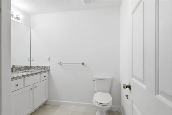 a bathroom with a granite countertop toilet and sink