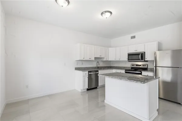 a kitchen with stainless steel appliances granite countertop a stove top oven a sink and dishwasher