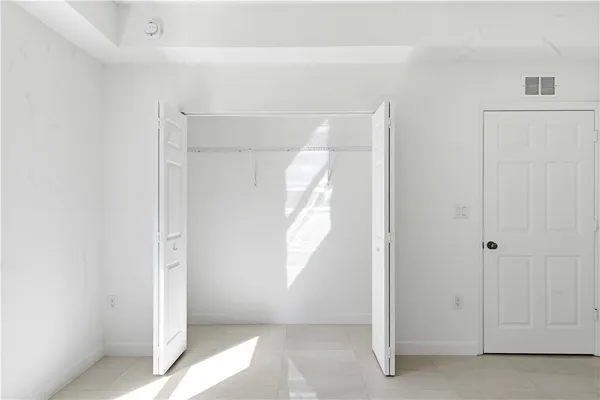 a view of empty room with window and ceiling fan