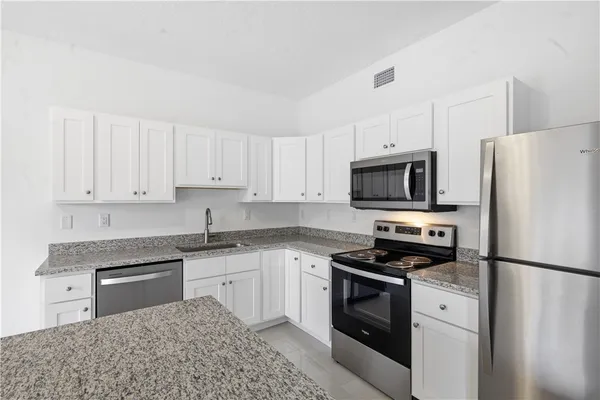 a kitchen with white cabinets and stainless steel appliances