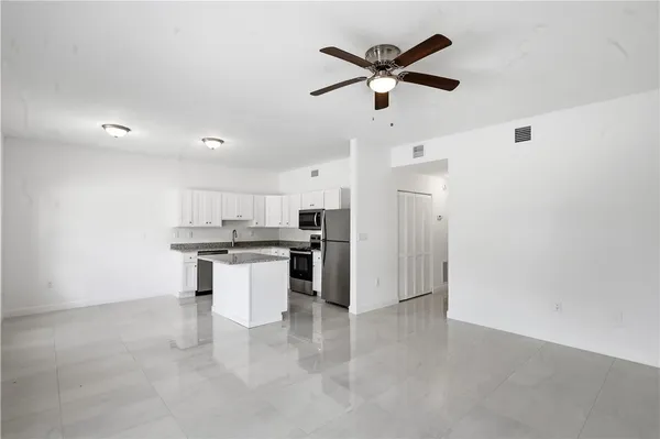a kitchen with a refrigerator and white cabinets