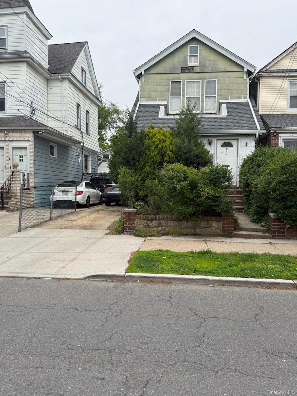 91-20 87th Street Queens, NY 11421 - Photo 1 of 1 a front view of a house with a yard and garage