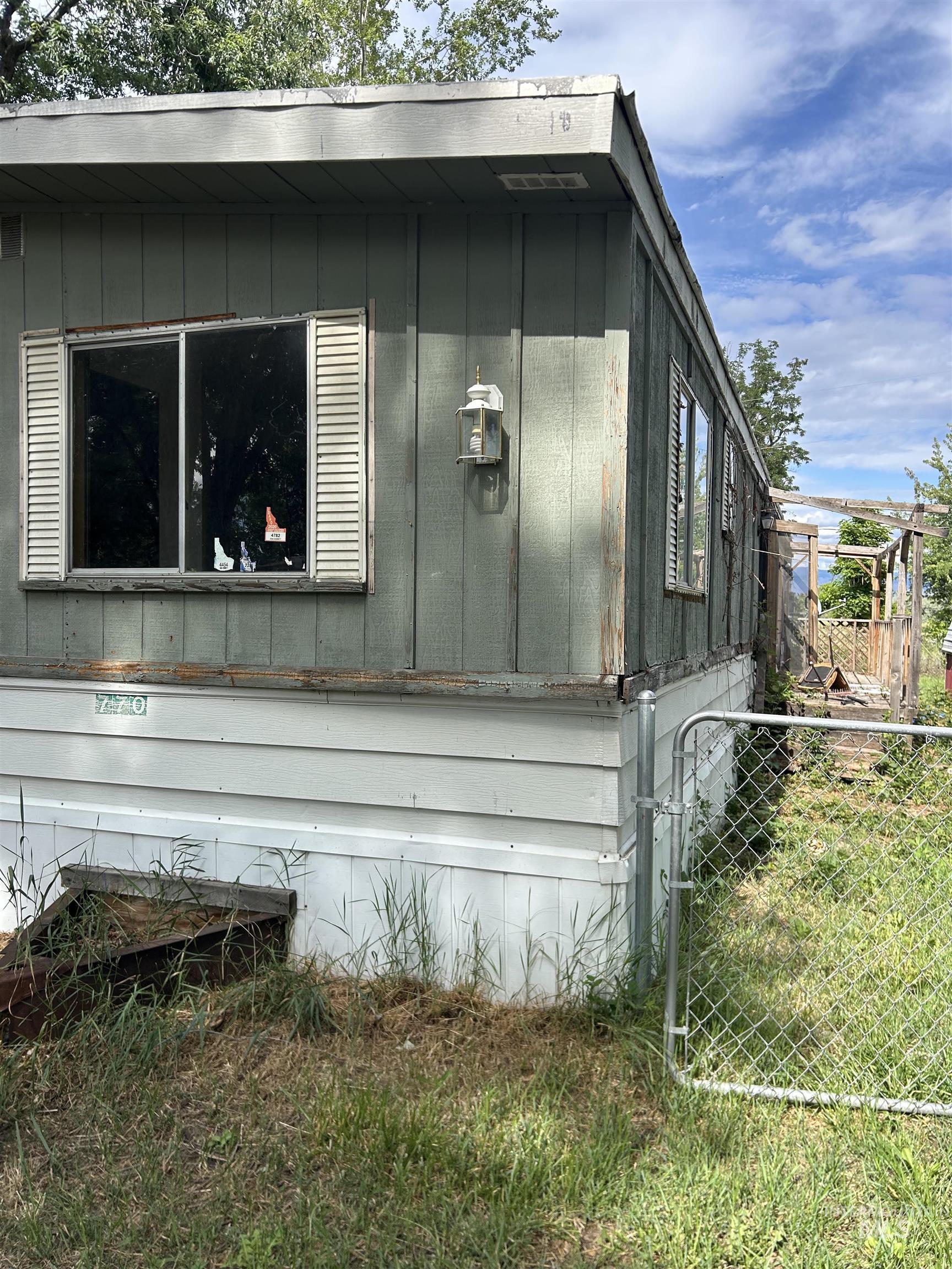 770 Dolson Lane Eagle, ID 83616 - Photo 3 of 11 Exterior siding featuring a window with louvered shutters and an attached outdoor light fixture