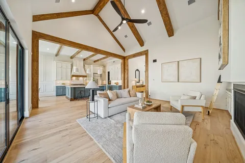 a dining room with wooden floor a chandelier a wooden table and chairs