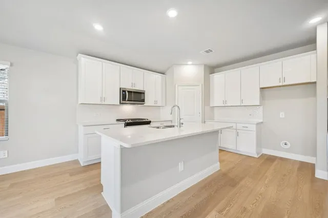 a kitchen with cabinets wooden floor and a sink