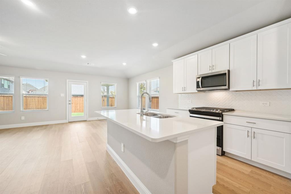 809 Sunflower Road Lavon, TX 75166 - Photo 5 of 32 a kitchen with stainless steel appliances granite countertop a sink stove and microwave