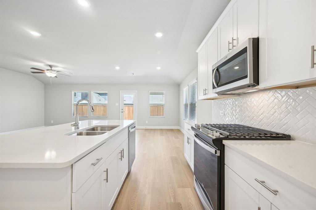 809 Sunflower Road Lavon, TX 75166 - Photo 6 of 32 a kitchen with stainless steel appliances granite countertop a sink stove and microwave