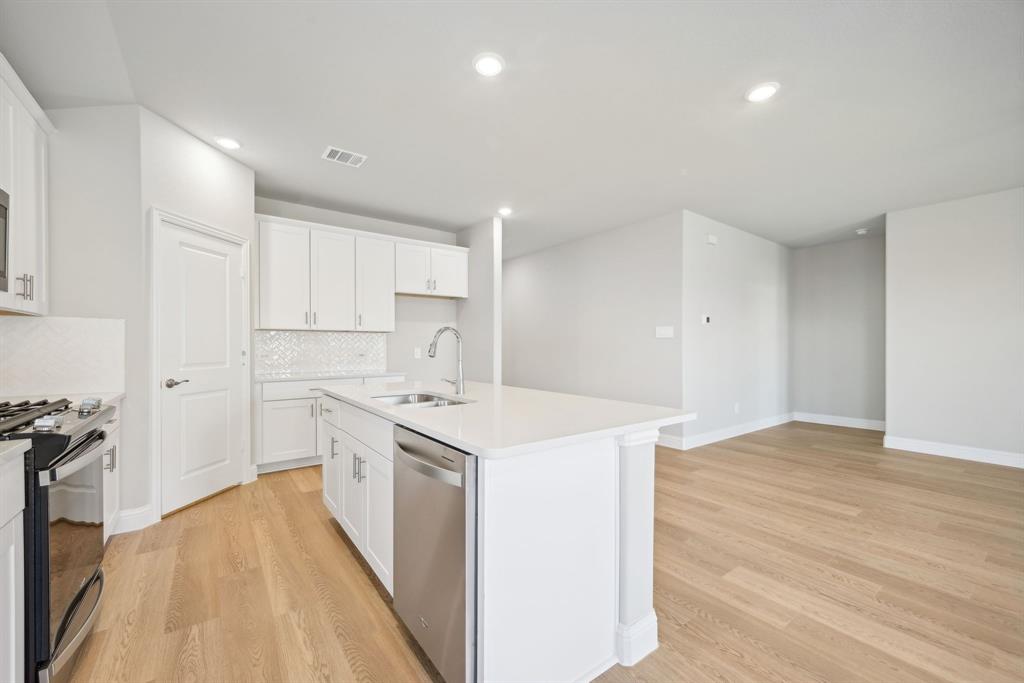 809 Sunflower Road Lavon, TX 75166 - Photo 7 of 32 a kitchen with a sink a stove cabinets and wooden floor