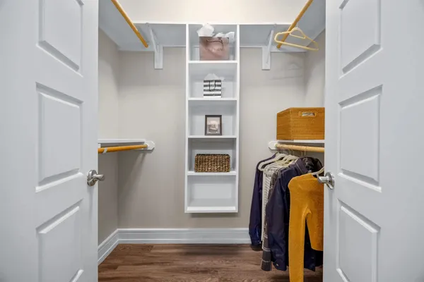 a view of walk in closet with clothes and shoes
