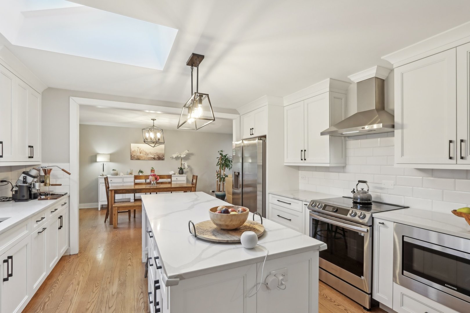 2542 Woodlawn Road Northbrook, IL 60062 - Photo 6 of 38 a kitchen with stainless steel appliances a stove a sink dishwasher a refrigerator and white cabinets with wooden floor