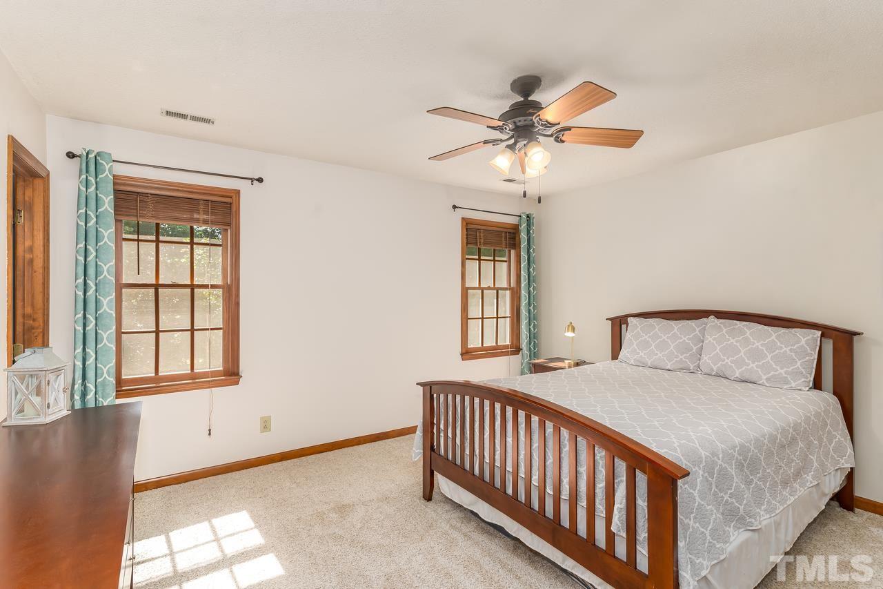 5504 Spring Pines Way Raleigh, NC 27616 - Photo 14 of 25 a bedroom with a bed and a chandelier