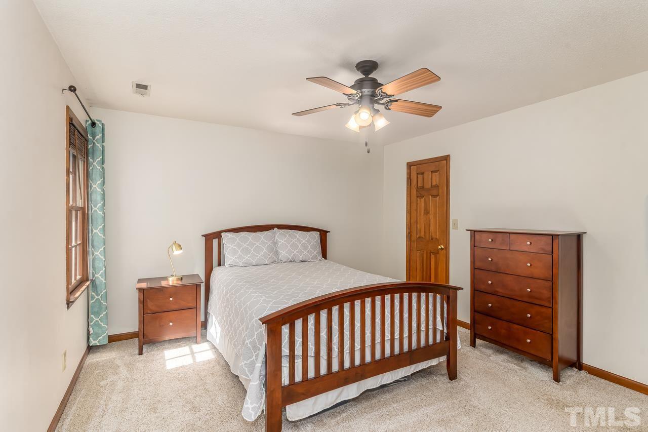 5504 Spring Pines Way Raleigh, NC 27616 - Photo 15 of 25 a bedroom with a bed and a chandelier