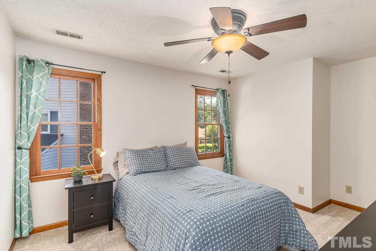 5504 Spring Pines Way Raleigh, NC 27616 - Photo 18 of 25 a bedroom with a bed and a chandelier