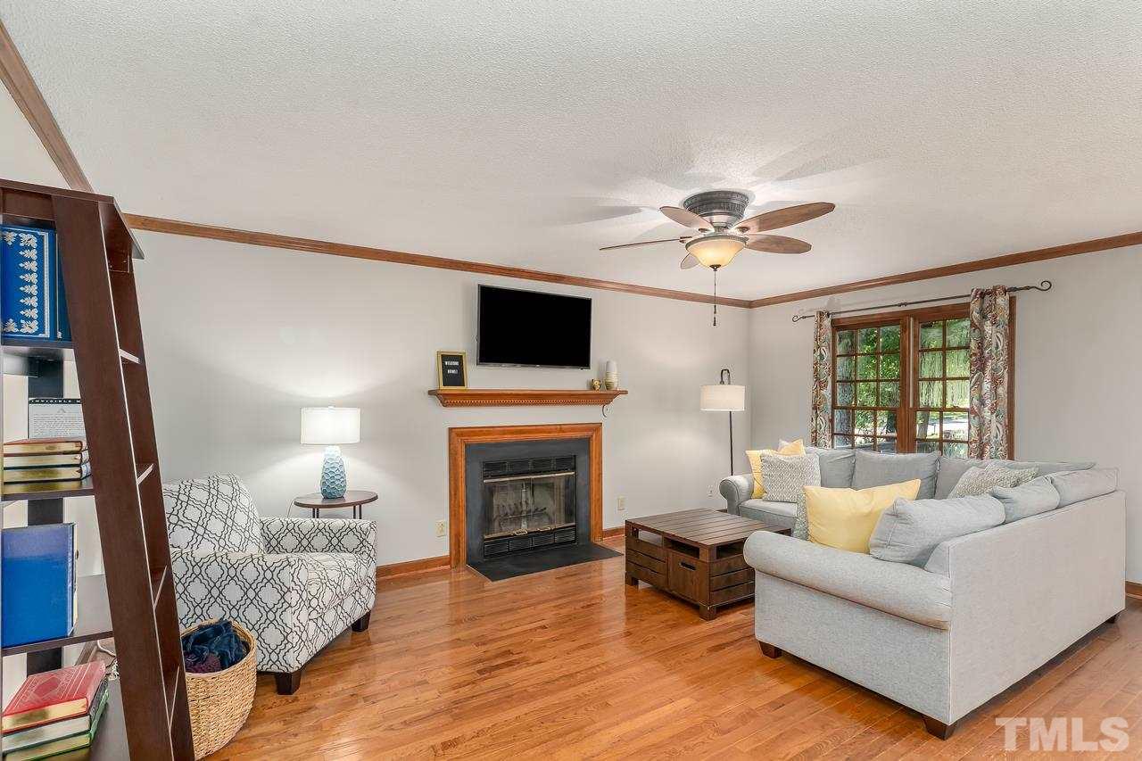 5504 Spring Pines Way Raleigh, NC 27616 - Photo 4 of 25 a living room with furniture a fireplace and a flat screen tv